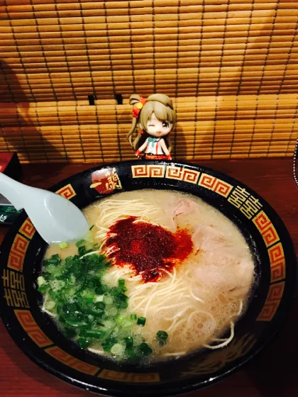 A bowl of Ichiran ramen with an anime figurine in front of it.