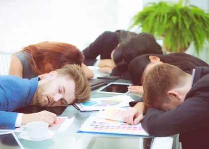 Five office workers asleep at their work brief table.