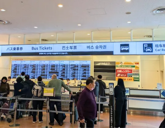Scene of people lining up to purchase bus tickets at the bus ticket counter.