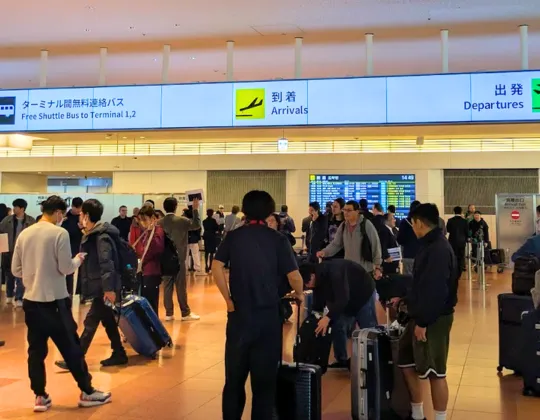 Busy scene at haneda airport of people navigating to the departure, arrival lobbies, and bus terminals