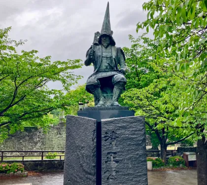 Statue of Kiyomasa Kato seated in full armor and wearing signature tall, pointed hat, naga-eboshi style helmet