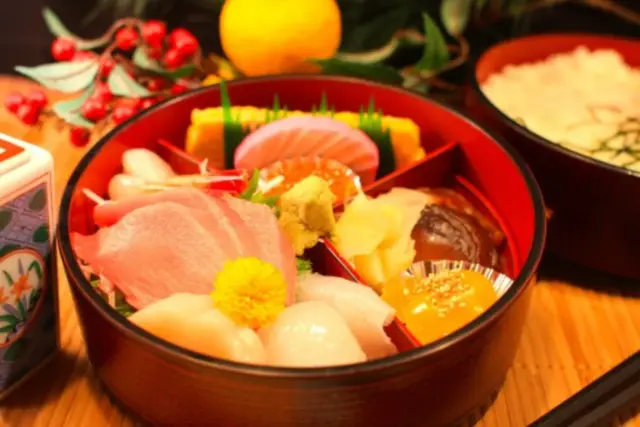 Vibrant cuts of sashimi, including hotate and otoro, served in a traditional Japanese bowl.