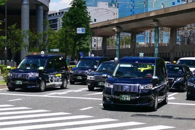 Japanese taxis driving on a city street.