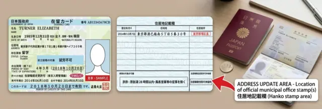 Japanese Residence Card and passport with arrow pointing to the official address update area.