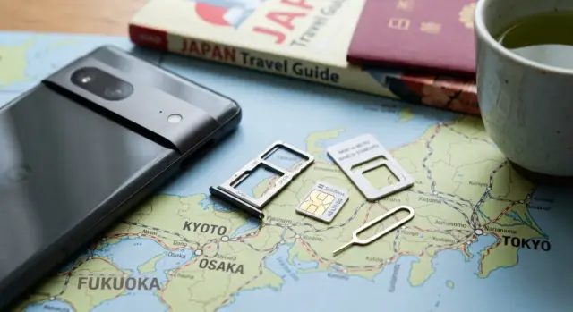 Close-up of a smartphone SIM tray next to a SIM card and adapter.