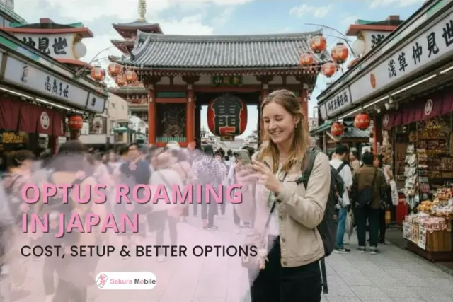 A smiling tourist uses her phone in front of the large Kaminarimon gate at Senso-ji temple in Tokyo.